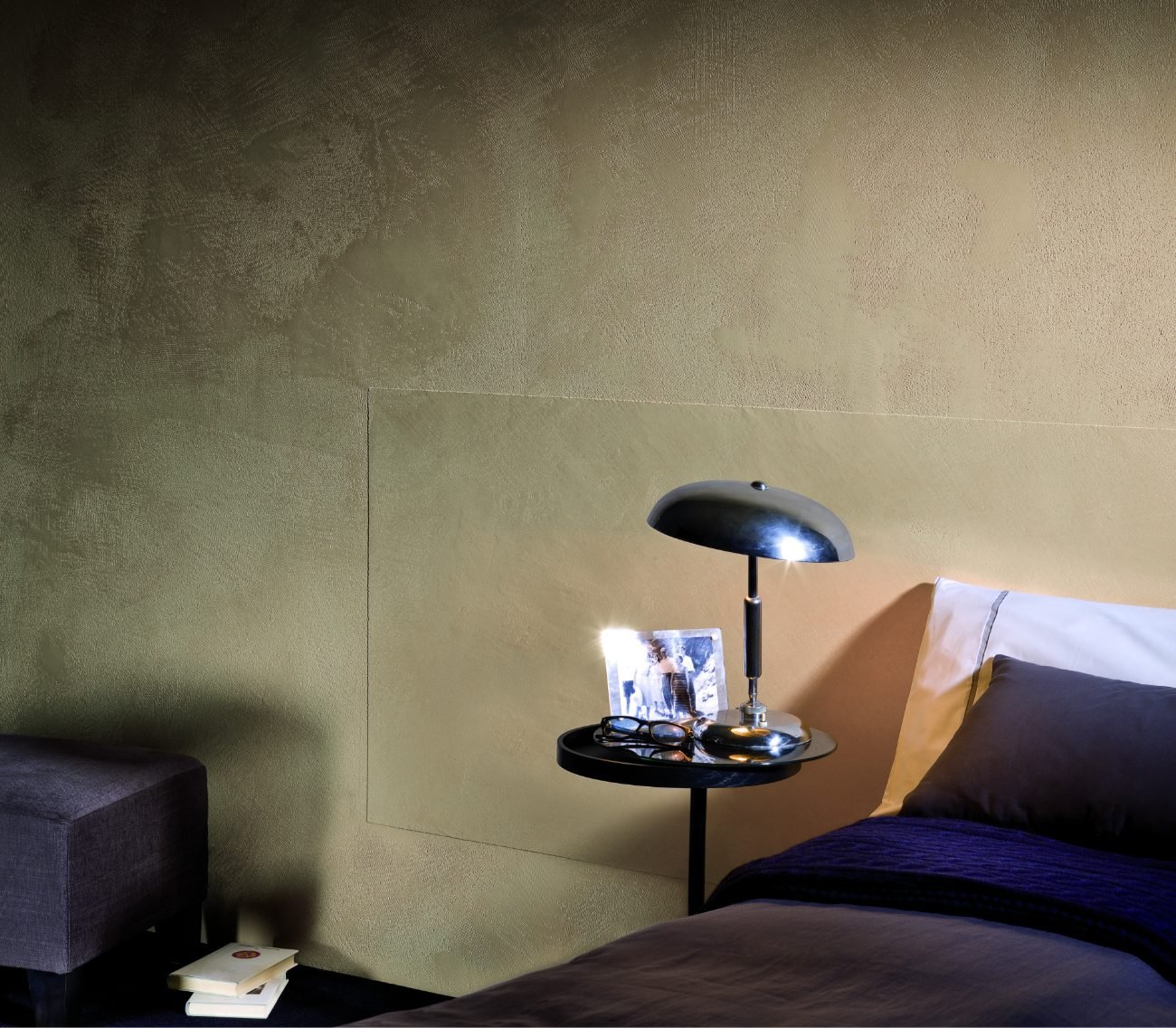 Clay wash eco paint on a bedroom feature wall in a soft olive tone