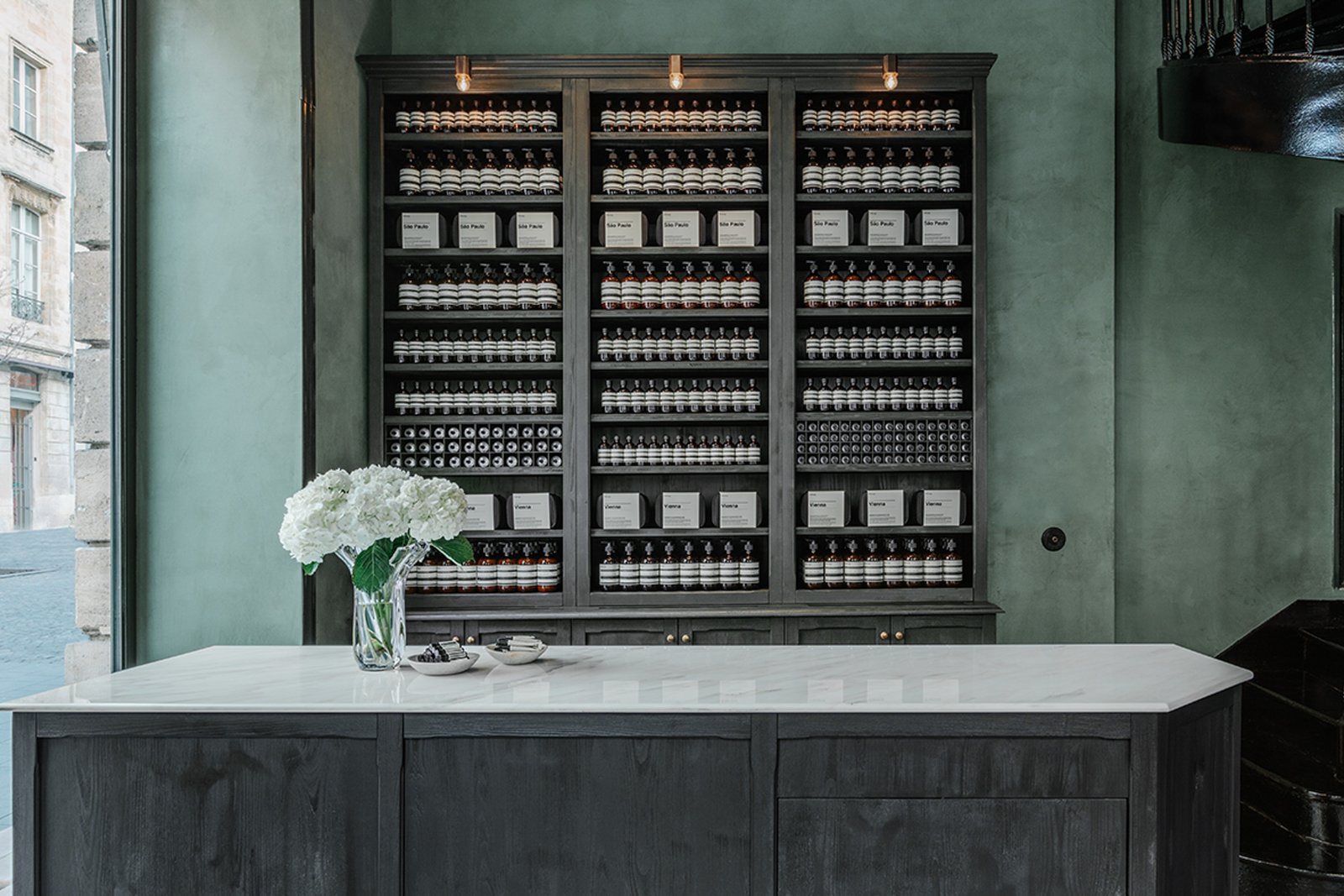Custom green clay plaster detail at Aesop Bordeaux, applied by AG Argildesign.