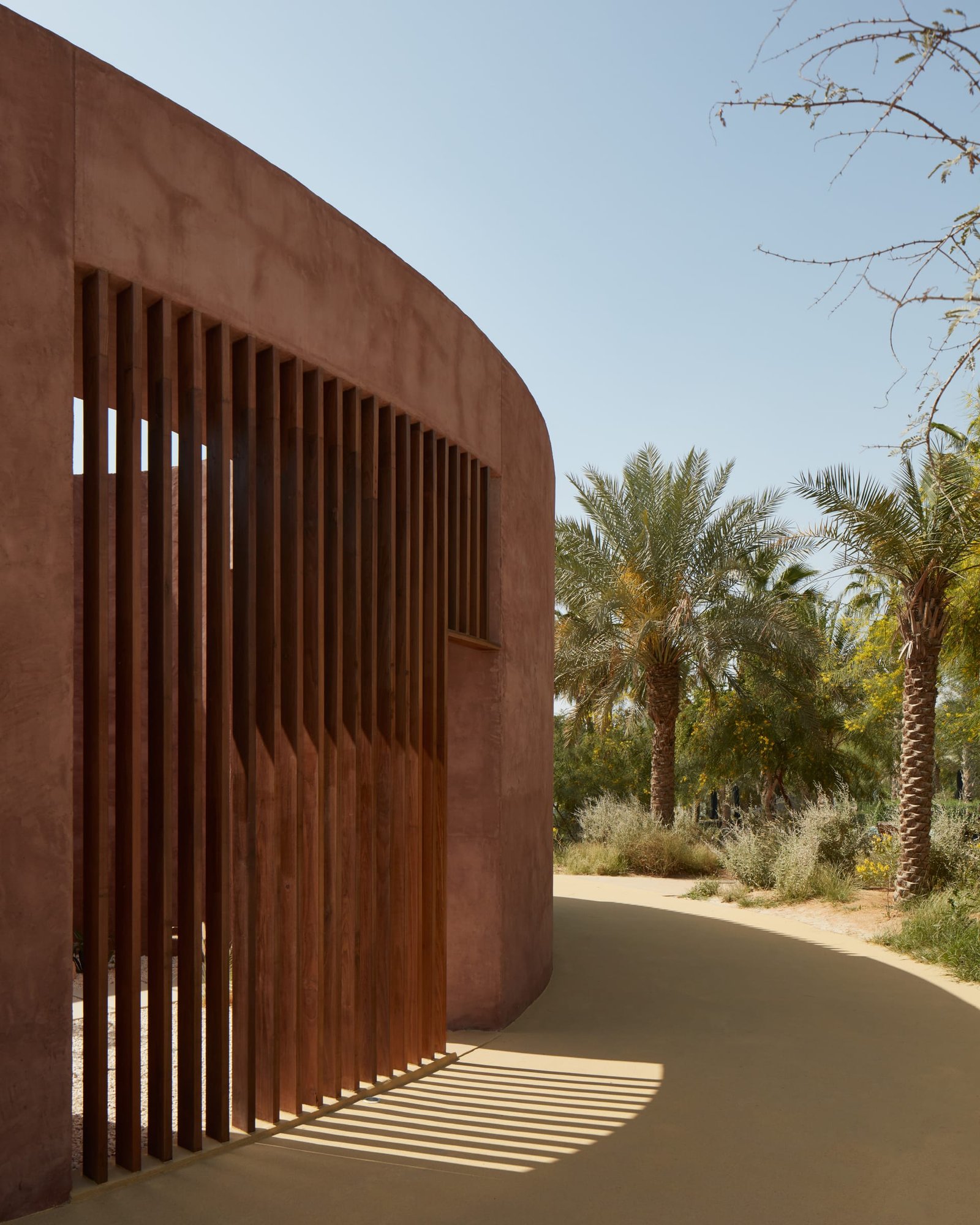 Curved white exterior clay plaster facade of the Canvas Events Pavilion, Dubai