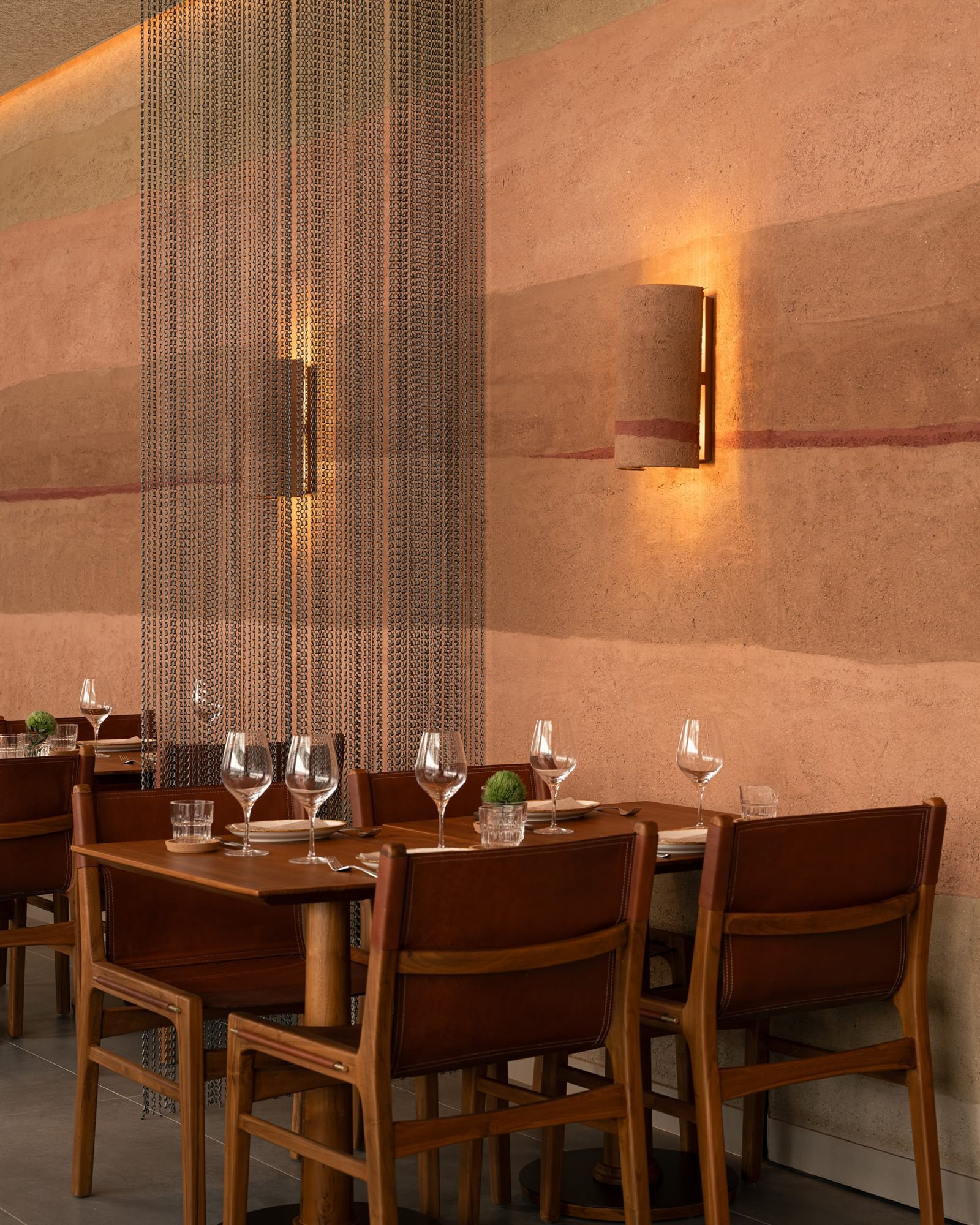 Stratified rammed earth plaster wall above the dining tables at Fireplace by Bedrock, Singapore