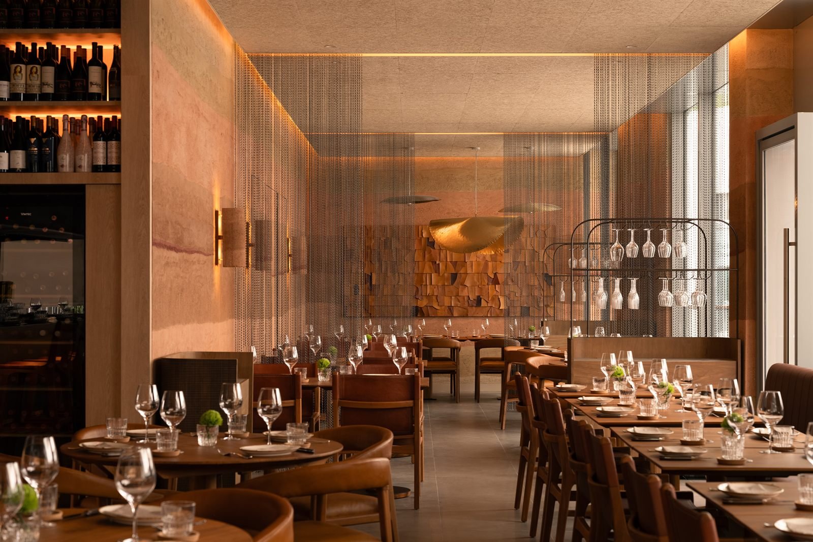 Dining room at Fireplace by Bedrock, Singapore, with rammed earth plaster walls and an open wood fire