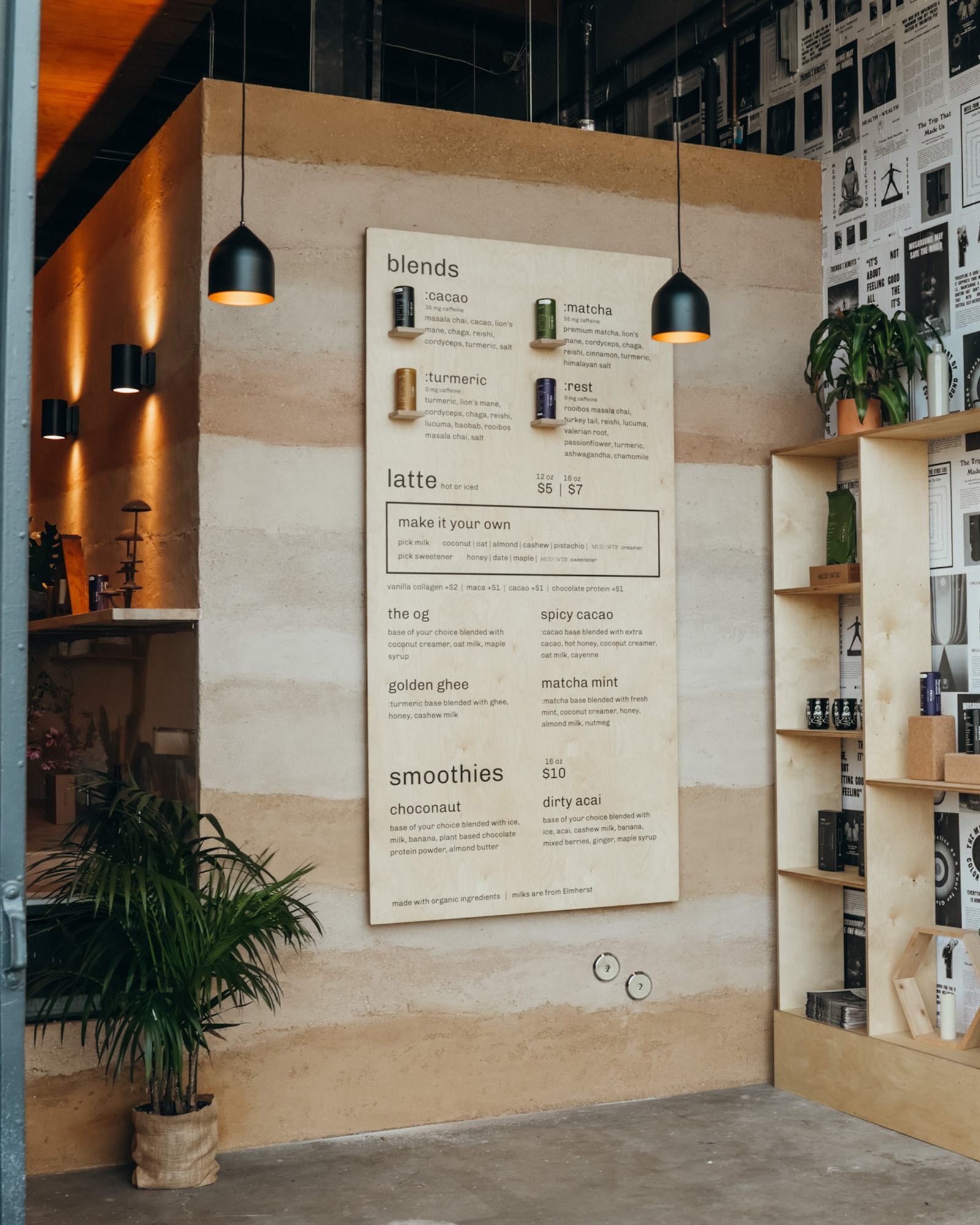 Menu board mounted on the Rammed Earth finish bar at MUD\WTR Gather, Santa Monica, beside plywood shelving