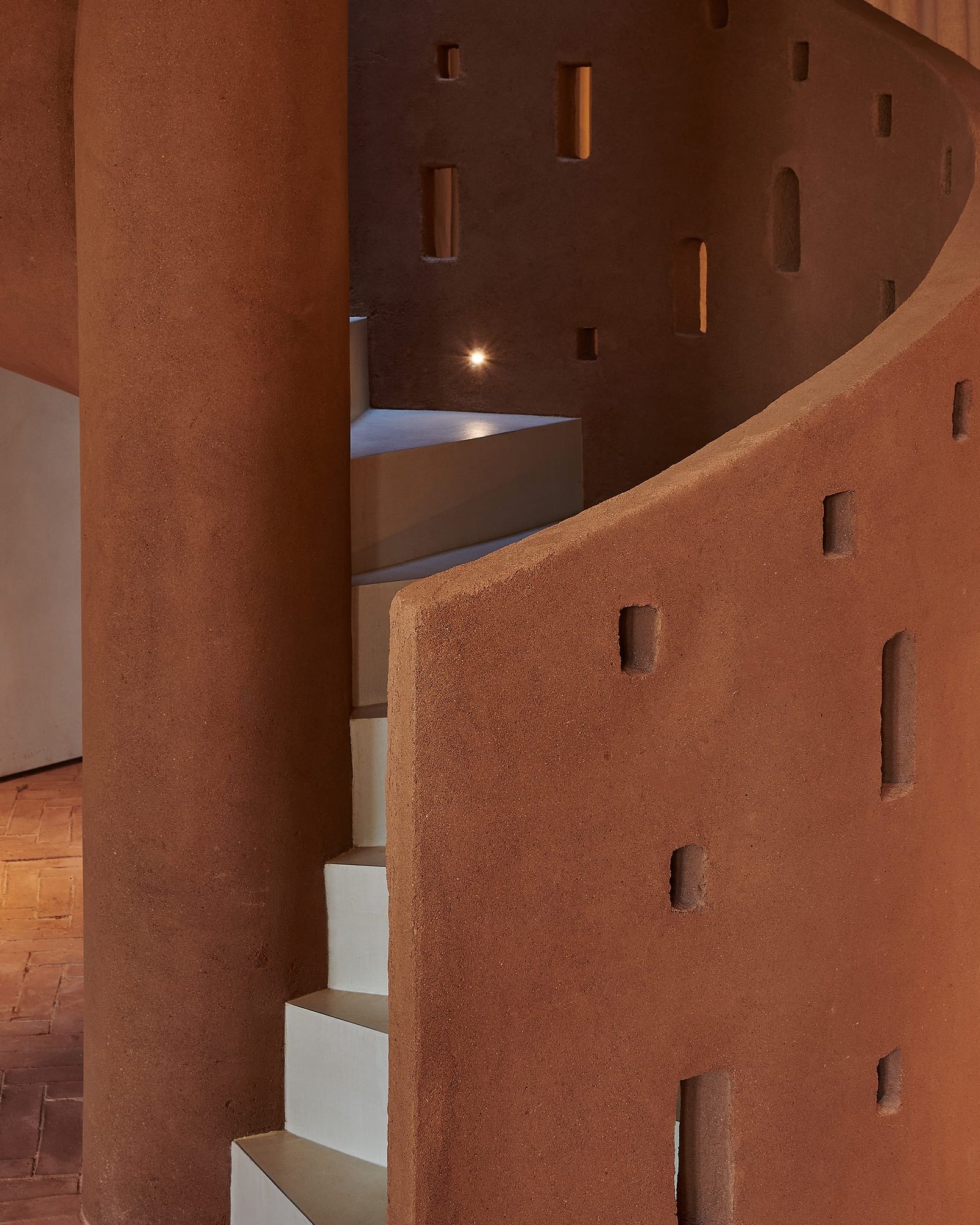 Punched openings in smoothed Demi Rustic clay plaster on the stair at Villa 515