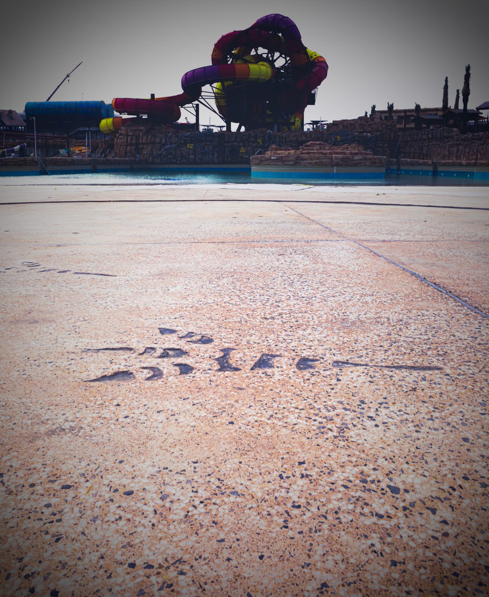 Wave pool deck at Meryal Waterpark in Exposed Plus exposed-aggregate decorative concrete with imprinted footprint trails.