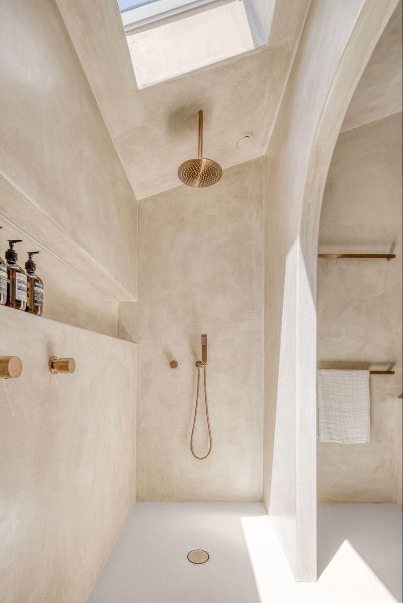 Seamless microcement shower room with a bench and recessed niche at Katara Hills, LXR Doha