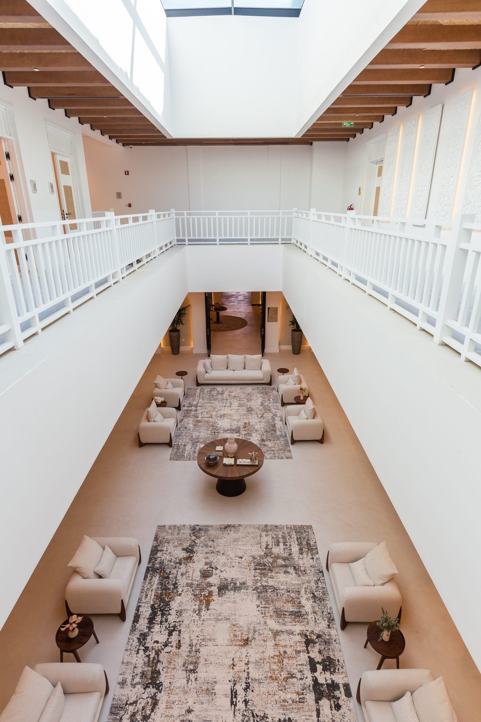 Microcement surfaces continuing from floor to walls and joinery in the atrium lounge at Maysan, LXR Doha
