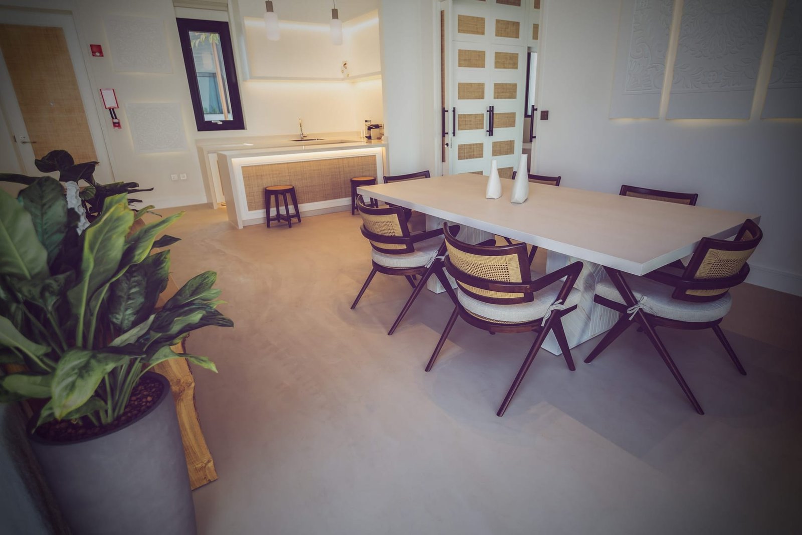 Microcement walls and floor in the dining room at Maysan, LXR Doha, with timber furniture