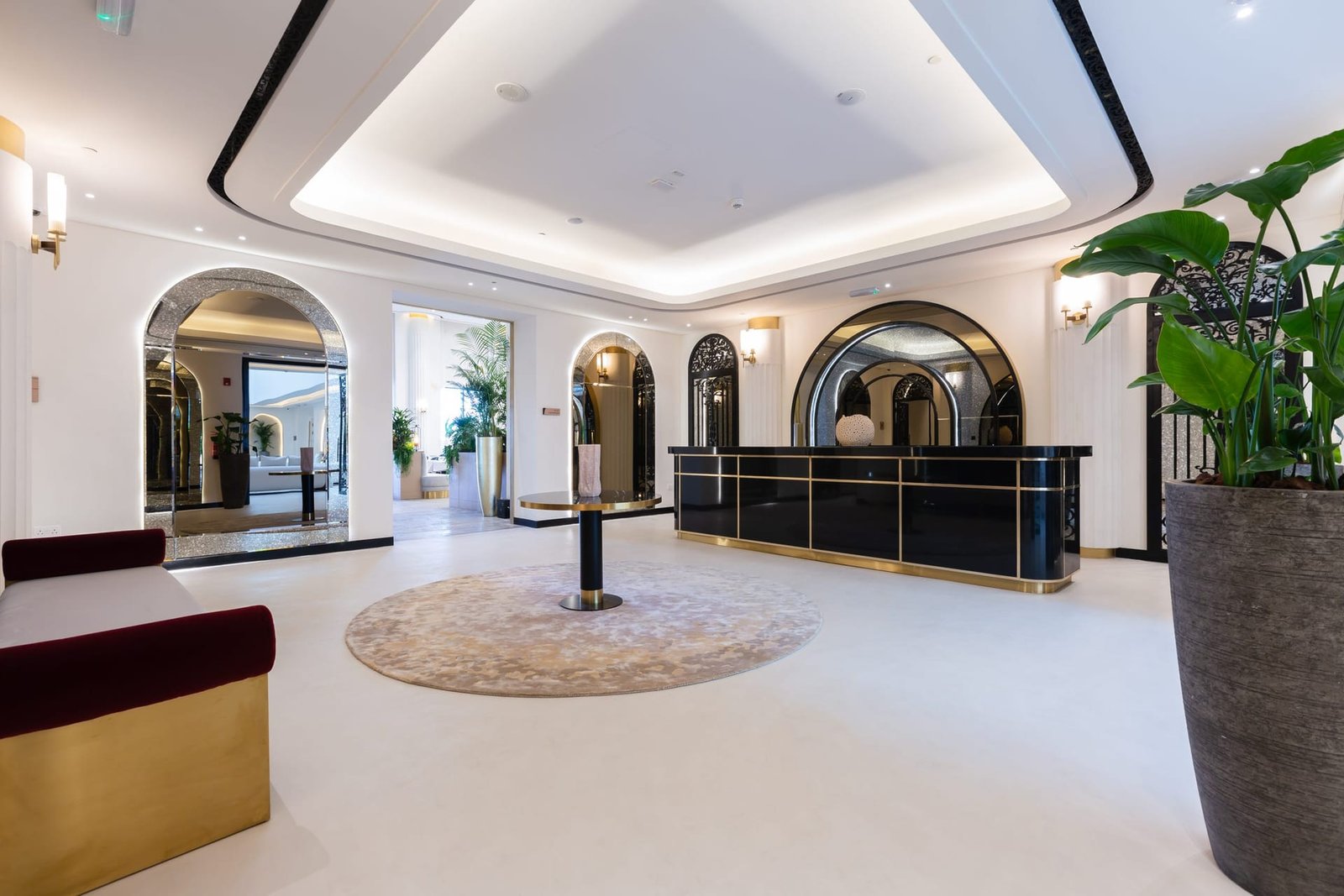 Lounge at Maysan Doha with brass counter and arched mirrors above a seamless cream microcement floor