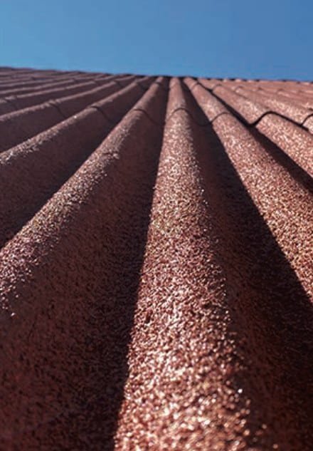 Close view of brown projected cork on a corrugated roof against a blue sky
