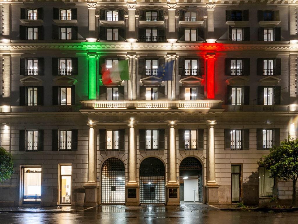 Facade of Banca d Italia, Rome, at night, floodlit in the green, white and red of the Italian flag