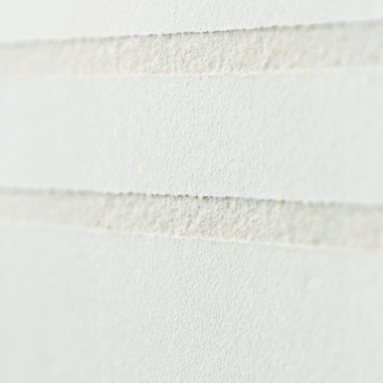 Seamless acoustic plaster ceiling meeting a wall with no visible joint