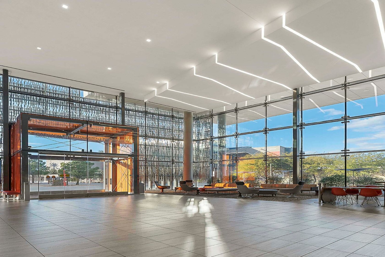 Glazed double-height entrance hall at UNLV, Las Vegas, under a seamless white acoustic ceiling