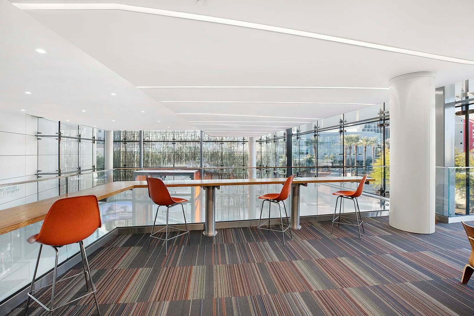 Upper-level study counter at UNLV, Las Vegas, beneath a seamless white acoustic ceiling with recessed linear lighting